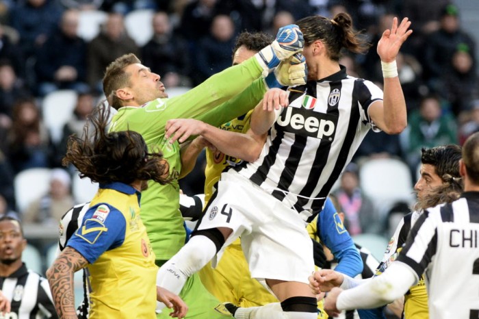 Chievo Verona goalkeeper Albano Bizzarri, top left, and Juventus' Martin Caceres collide as they go for the ball during a Serie A soccer match between Juventus and Chievo Verona at the Juventus stadium, in Turin, Italy, Sunday, Jan. 25, 2015. (AP Photo/Massimo Pinca) ORG XMIT: XMP105
